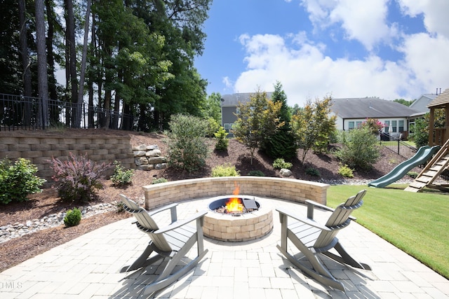 view of patio featuring a fire pit, a playground, and fence