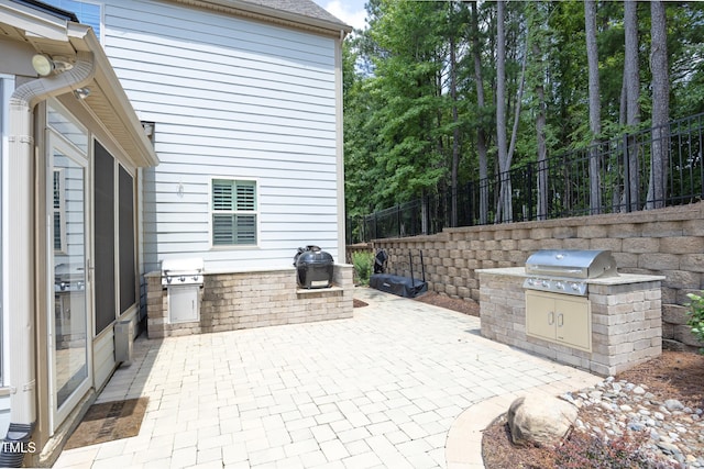 view of patio / terrace featuring area for grilling, an outdoor kitchen, and fence