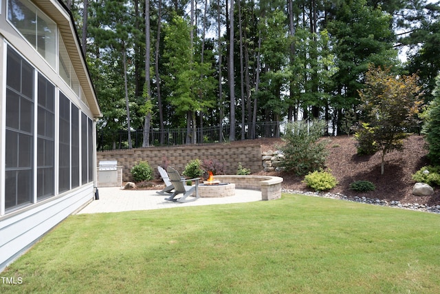 view of yard featuring a fire pit, a patio, and fence