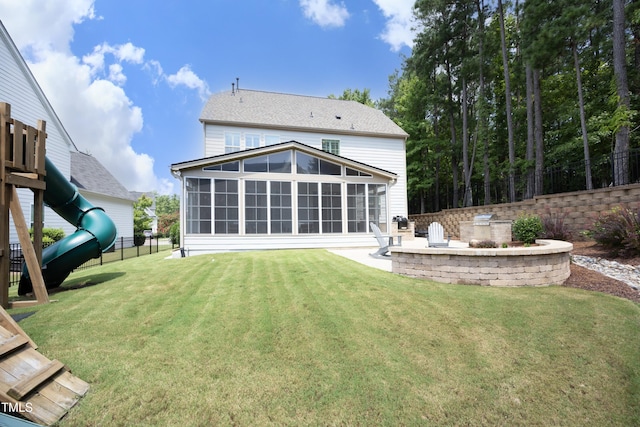 back of property featuring a playground, fence, a lawn, a sunroom, and area for grilling