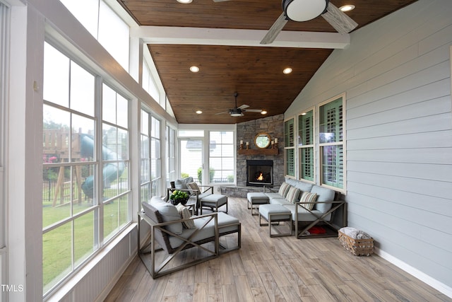 sunroom with a stone fireplace, lofted ceiling, wood ceiling, and ceiling fan