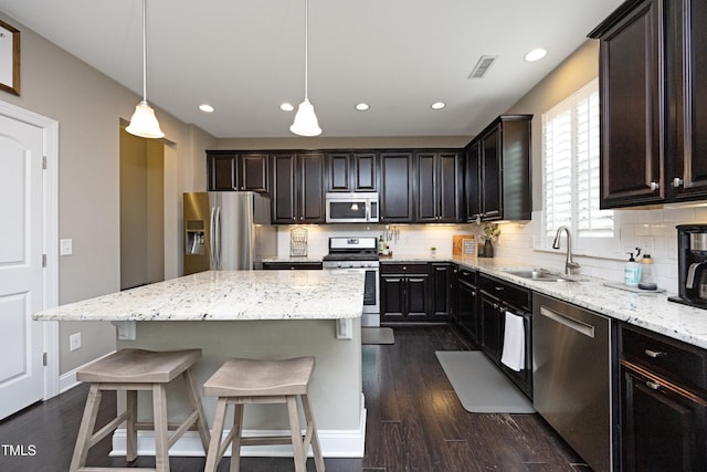 kitchen featuring a sink, tasteful backsplash, appliances with stainless steel finishes, and dark wood-style flooring