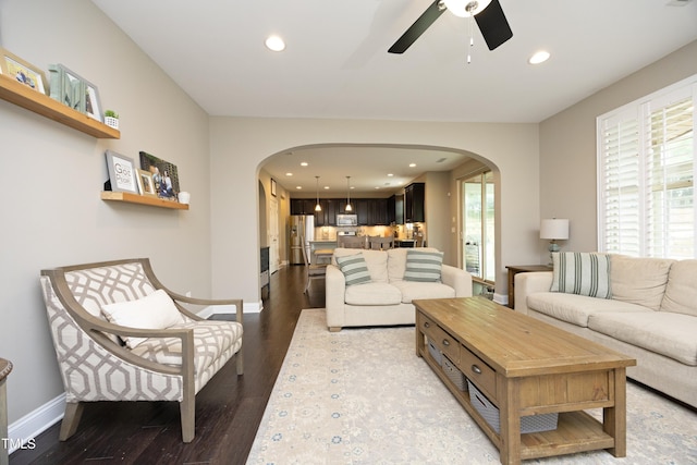 living room with wood finished floors, recessed lighting, a ceiling fan, and arched walkways