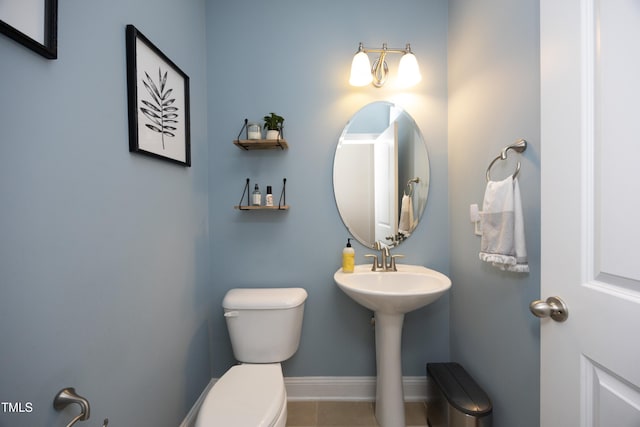 bathroom with tile patterned floors, baseboards, toilet, and a sink