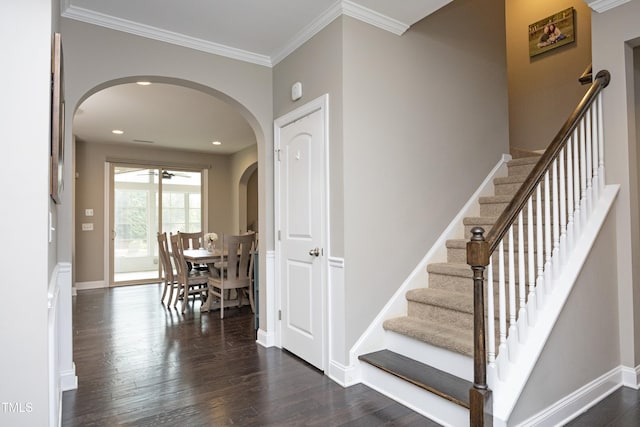 stairs featuring arched walkways, crown molding, baseboards, and wood finished floors