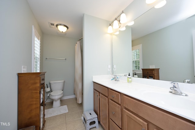 full bath with a sink, toilet, a wealth of natural light, and tile patterned floors