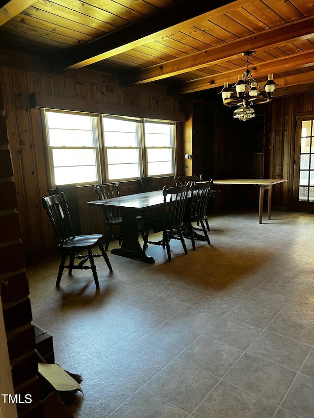 dining area with wooden ceiling, wooden walls, a notable chandelier, and beamed ceiling