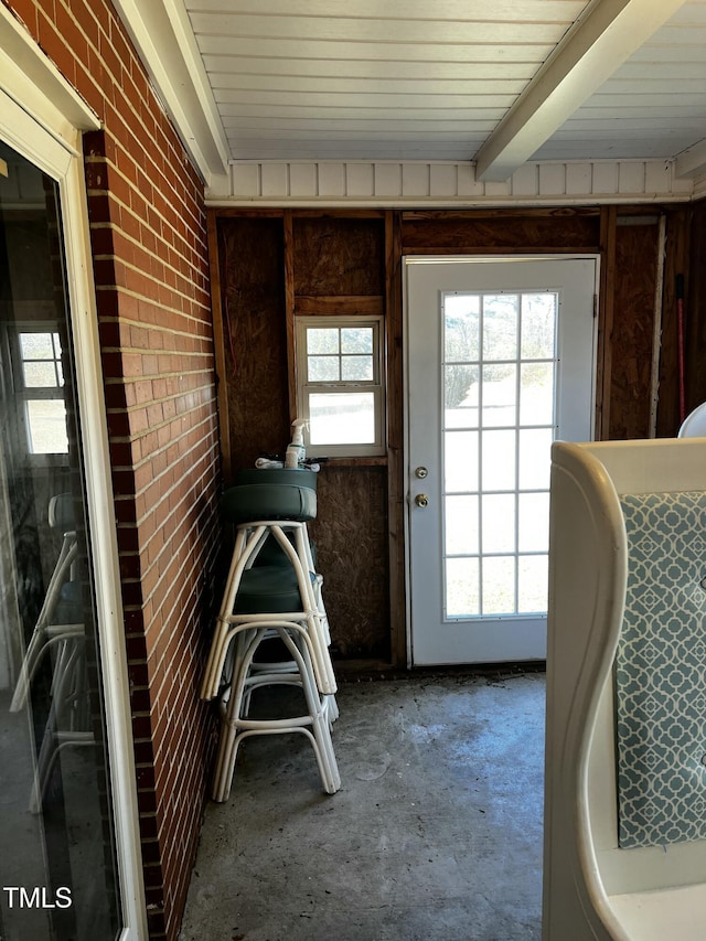 interior space featuring beamed ceiling, brick wall, and wood ceiling