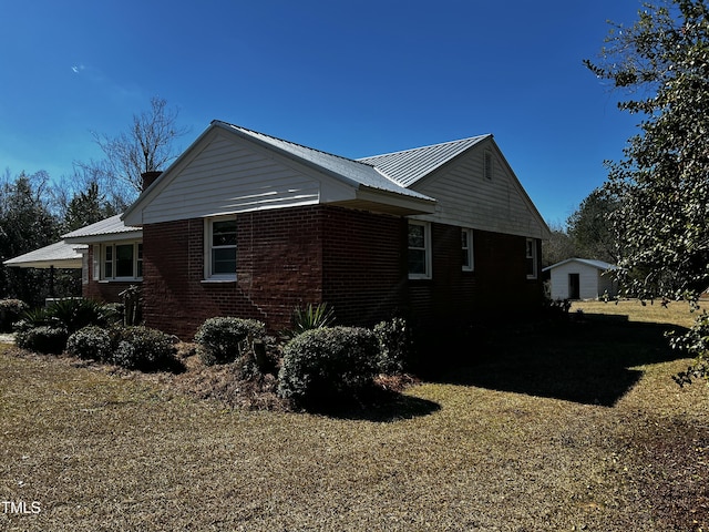 view of side of home featuring brick siding and metal roof