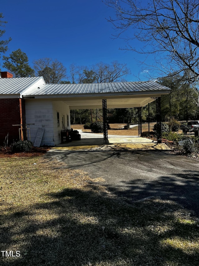 view of vehicle parking featuring aphalt driveway and a carport