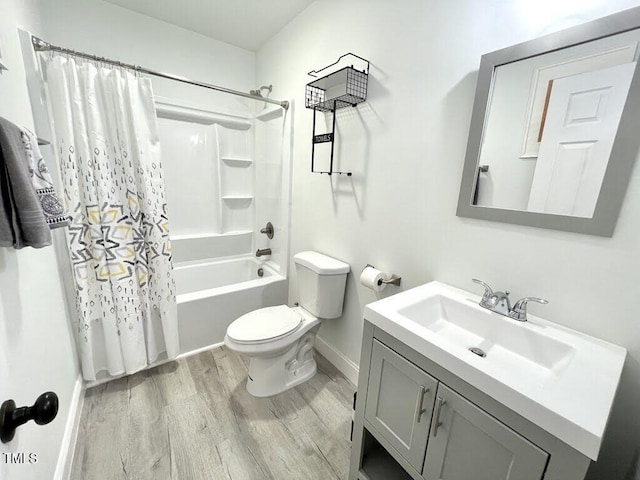 full bath with shower / bathtub combination with curtain, vanity, toilet, wood finished floors, and baseboards