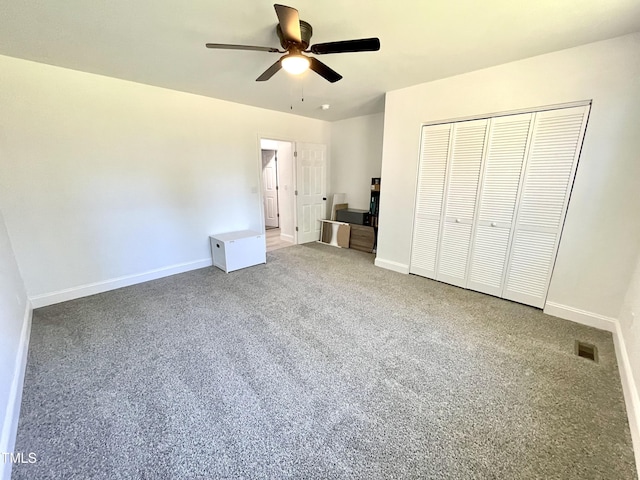 unfurnished bedroom with visible vents, baseboards, a closet, a ceiling fan, and carpet