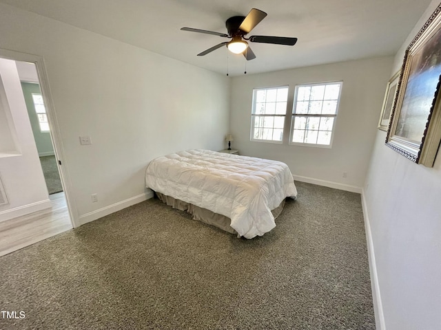 carpeted bedroom with ceiling fan, baseboards, and multiple windows