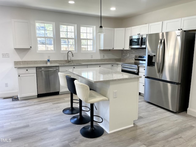 kitchen with a sink, white cabinets, and stainless steel appliances