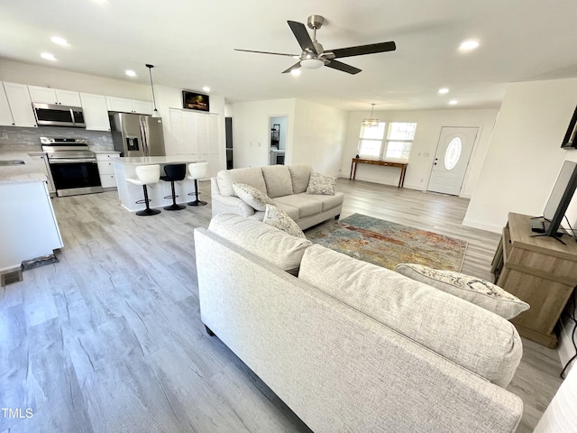 living area with visible vents, baseboards, ceiling fan, light wood-type flooring, and recessed lighting