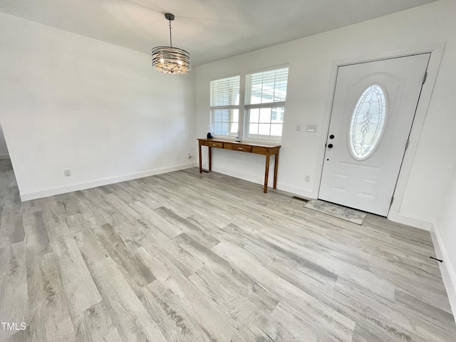 entrance foyer featuring baseboards, light wood-type flooring, and a notable chandelier