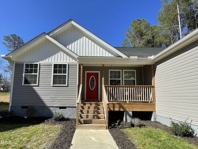 view of exterior entry with board and batten siding, a porch, and crawl space