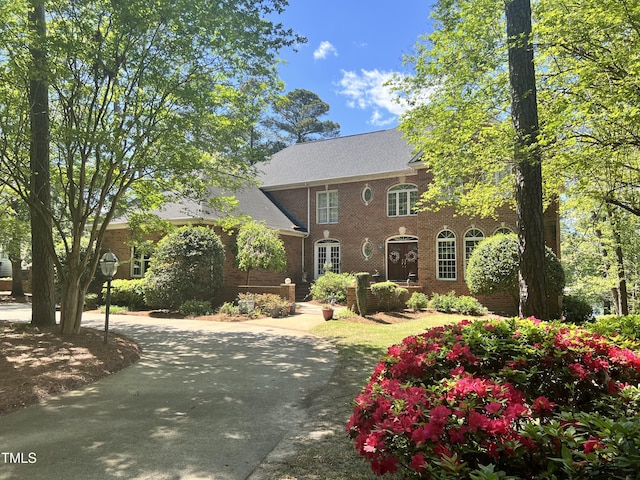 colonial house with brick siding and curved driveway