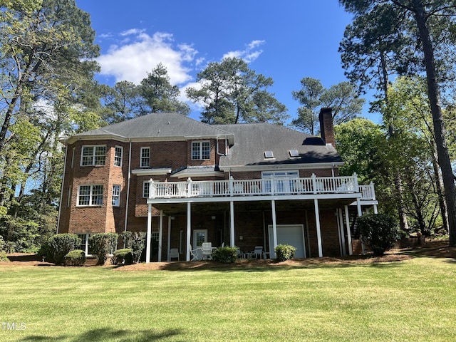 rear view of property featuring a lawn, a wooden deck, and brick siding