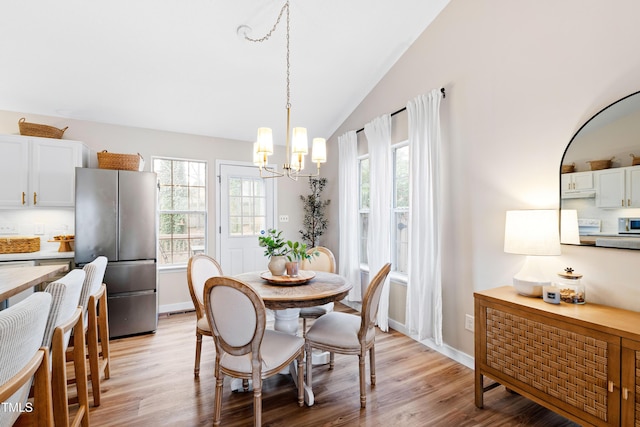 dining space with lofted ceiling, light wood-style flooring, and a wealth of natural light