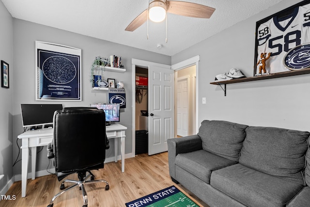 office space featuring a textured ceiling, a ceiling fan, baseboards, and wood finished floors