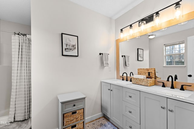 bathroom with a sink, baseboards, a shower with curtain, and double vanity