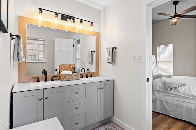 bathroom with ceiling fan, ensuite bath, wood finished floors, and a sink