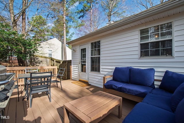 wooden terrace featuring an outdoor living space, outdoor dining area, and fence