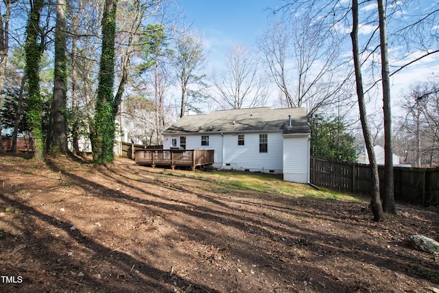 rear view of property with crawl space, a deck, and fence