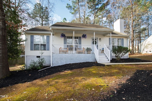 view of front of house featuring crawl space, a porch, and a chimney