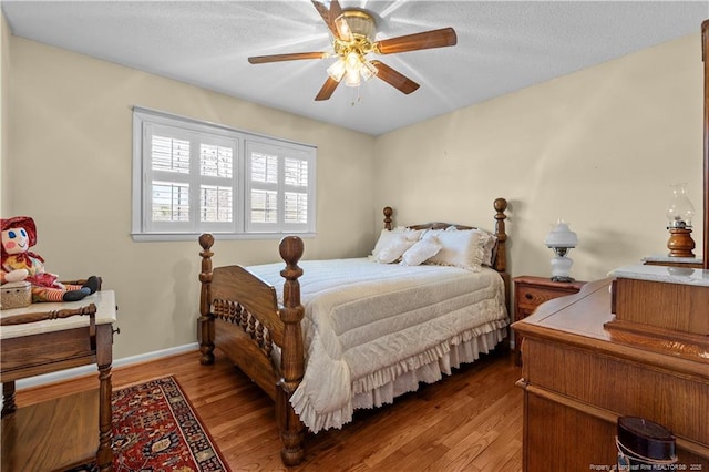 bedroom with baseboards, a textured ceiling, and light wood finished floors