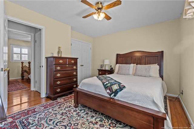 bedroom featuring ceiling fan, baseboards, and wood finished floors