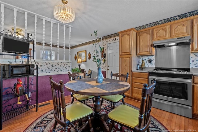 dining area featuring visible vents, an inviting chandelier, and light wood finished floors