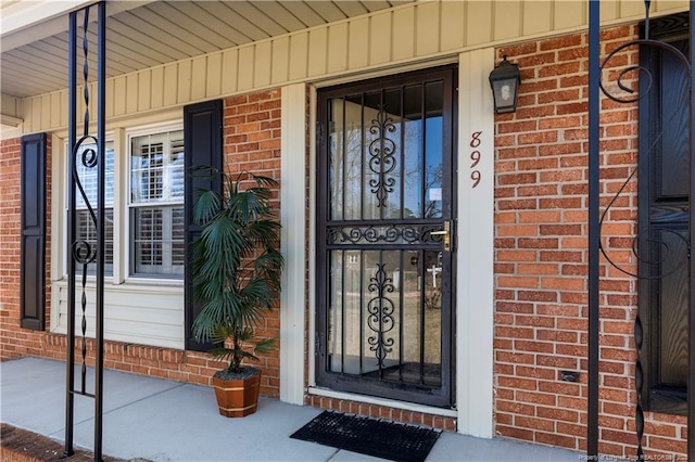 entrance to property with brick siding and covered porch