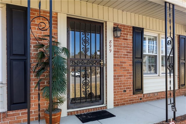 property entrance with brick siding and covered porch