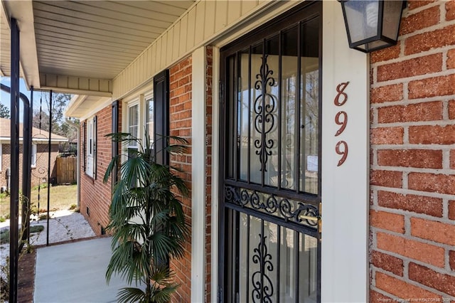 view of exterior entry featuring brick siding