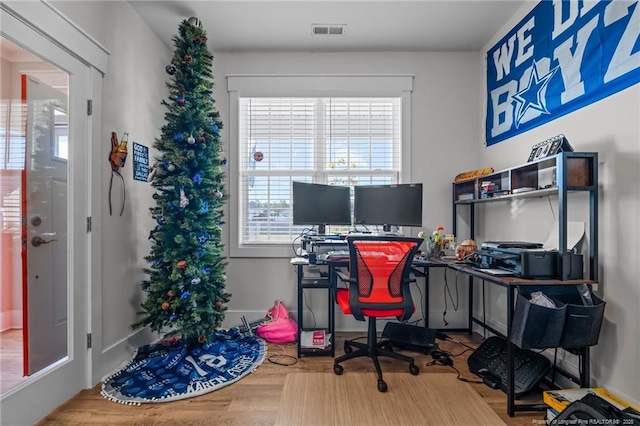 home office featuring visible vents, baseboards, and wood finished floors