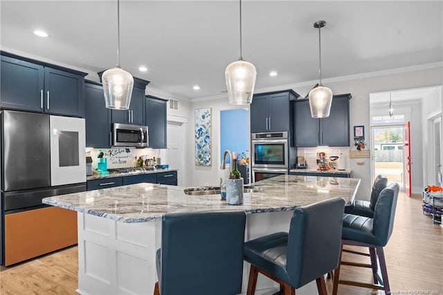 kitchen featuring a sink, a kitchen breakfast bar, backsplash, appliances with stainless steel finishes, and crown molding