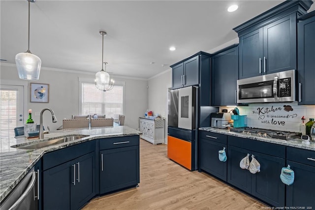 kitchen with light stone countertops, plenty of natural light, a sink, ornamental molding, and stainless steel appliances