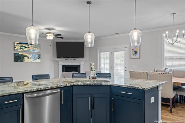 kitchen with ornamental molding, a sink, stainless steel dishwasher, open floor plan, and a fireplace