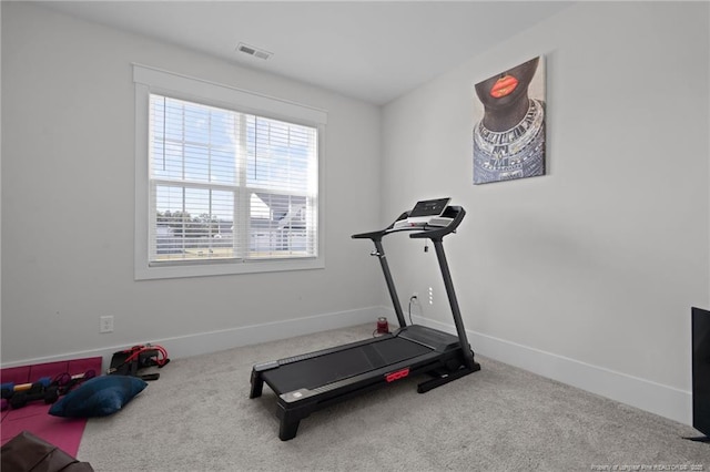 exercise room with baseboards, visible vents, and carpet floors