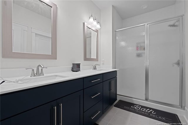 bathroom with tile patterned flooring, a shower stall, double vanity, and a sink