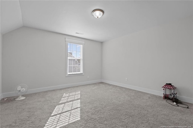 spare room with lofted ceiling, carpet, baseboards, and visible vents