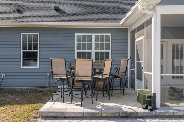 view of patio / terrace featuring outdoor dining space and a sunroom