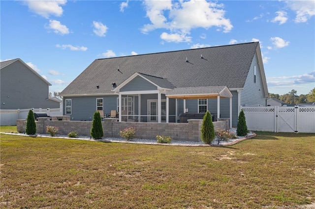 rear view of property featuring a gate, a yard, a fenced backyard, and a sunroom