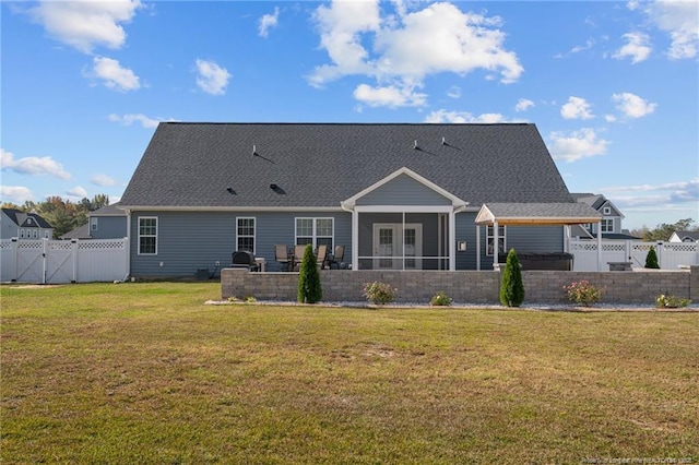 back of property featuring a gate, fence, a yard, roof with shingles, and a sunroom