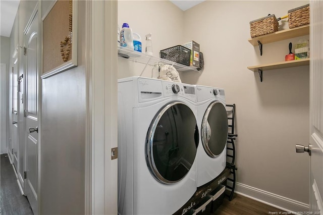 clothes washing area with dark wood finished floors, laundry area, baseboards, and separate washer and dryer