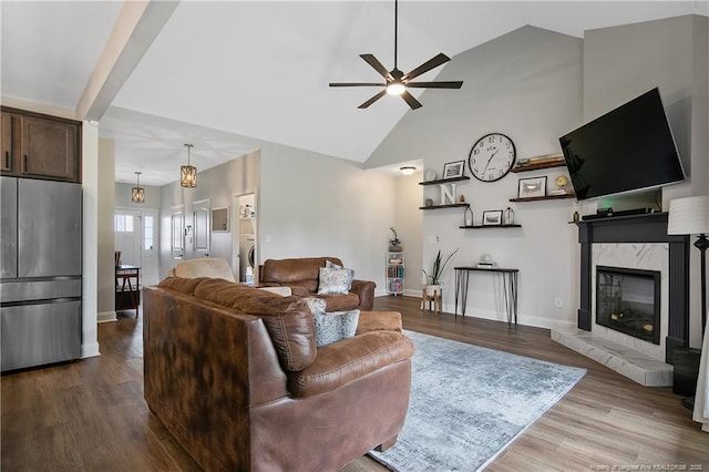 living area with a fireplace, high vaulted ceiling, dark wood-type flooring, and baseboards