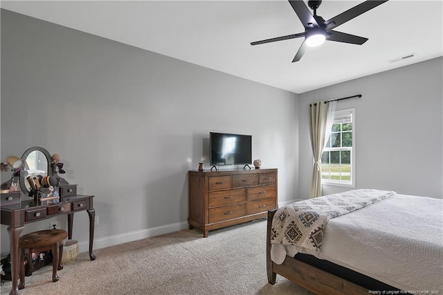 bedroom with light carpet, visible vents, a ceiling fan, and baseboards