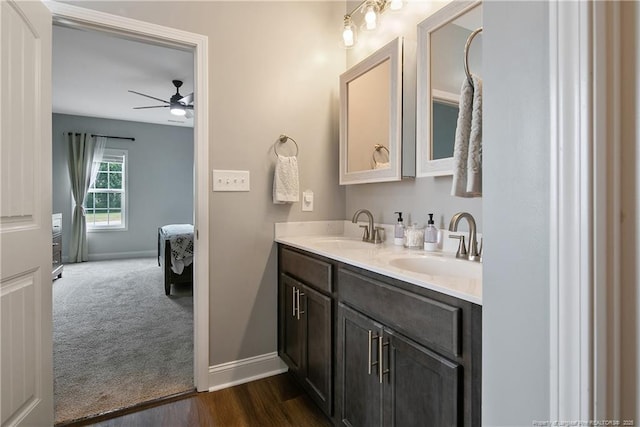 full bathroom with double vanity, baseboards, ensuite bathroom, and a sink